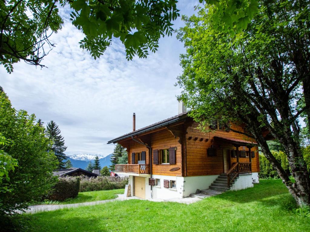 a wooden house with a staircase in a yard at Chalet Chalet Shambala by Interhome in Chesières