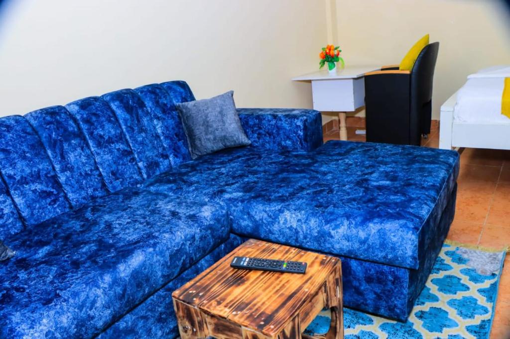 a blue couch in a living room with a table at Naivasha Studio- Rated Best in Naivasha