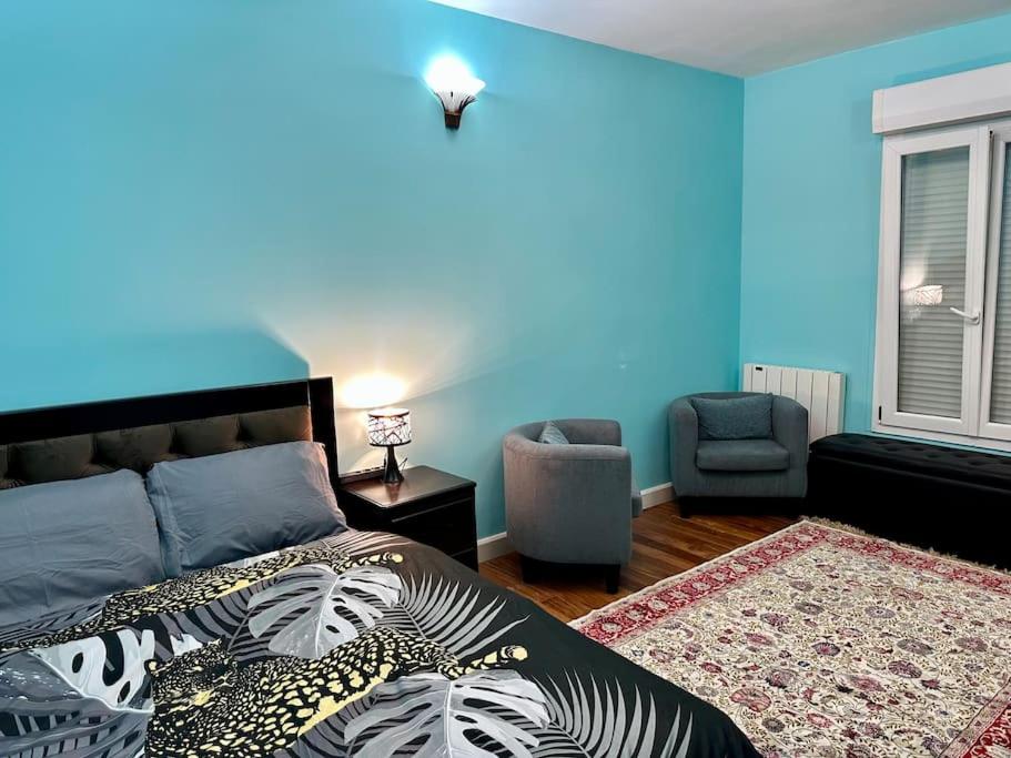 une chambre avec un lit et un mur bleu dans l'établissement Apparemment - Tour Eiffel - Grenelle, à Paris