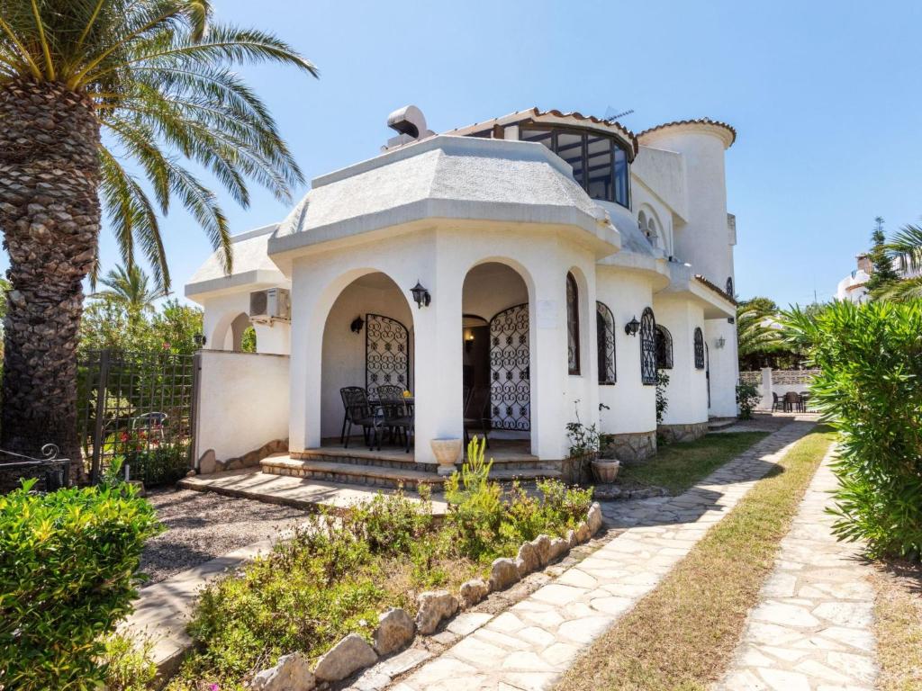 a white house with a palm tree in front of it at Holiday Home Avellaner by Interhome in Miami Platja