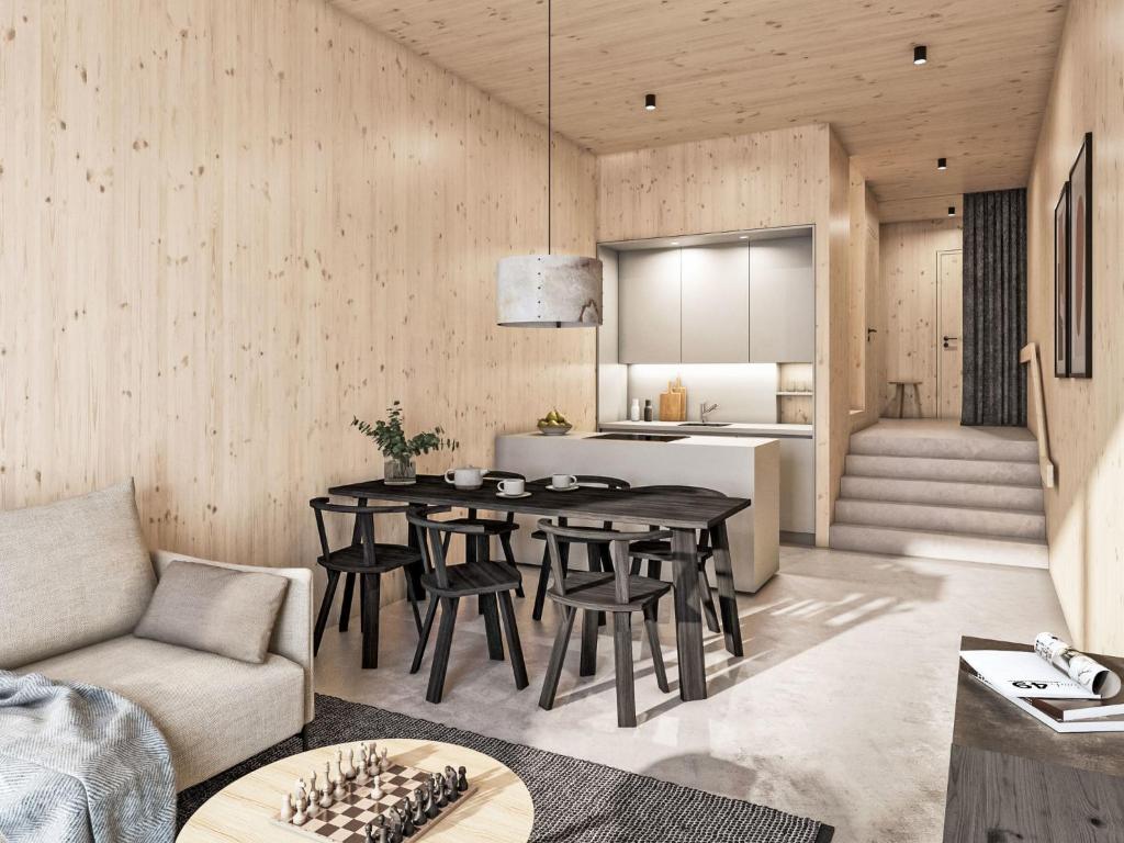 a kitchen and living room with a table and chairs at Apartment Hideaway Planneralm by Jufa Hotels-2 by Interhome in Donnersbach