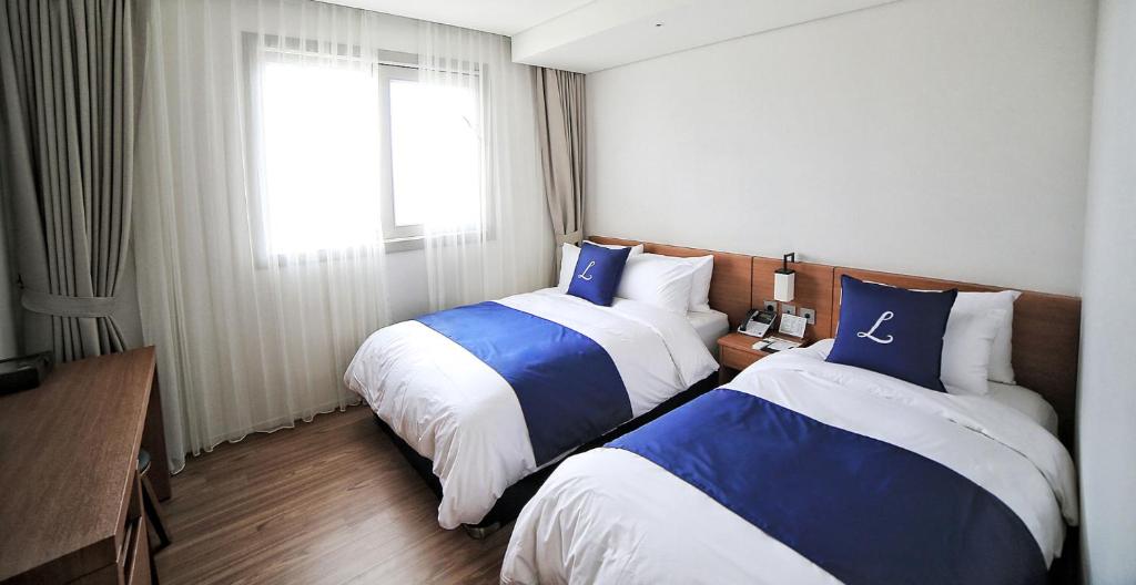 Postel nebo postele na pokoji v ubytování Lapis Hotel Namhae