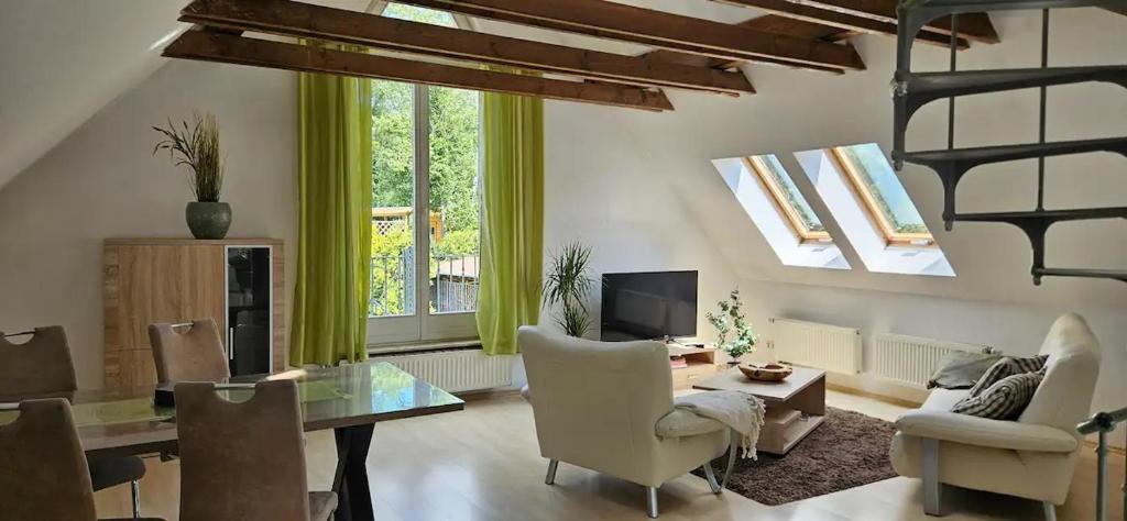 ドレスデンにあるFerienwohnung im Grünen von Dresdenの椅子とテーブルと窓のあるリビングルーム