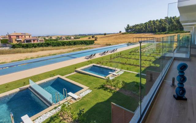 a view of two swimming pools on top of a building at Oikos Sani Suites in Sani Beach