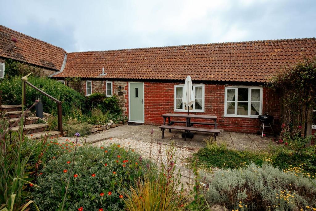 een stenen huis met een bank ervoor bij Carters Cottage - Rudge Farm Cottages in Bridport