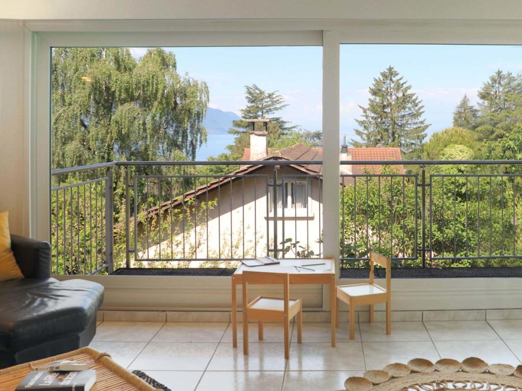 a living room with a table and a large window at Villa Route de la Muraz 9 by Interhome in Villeneuve