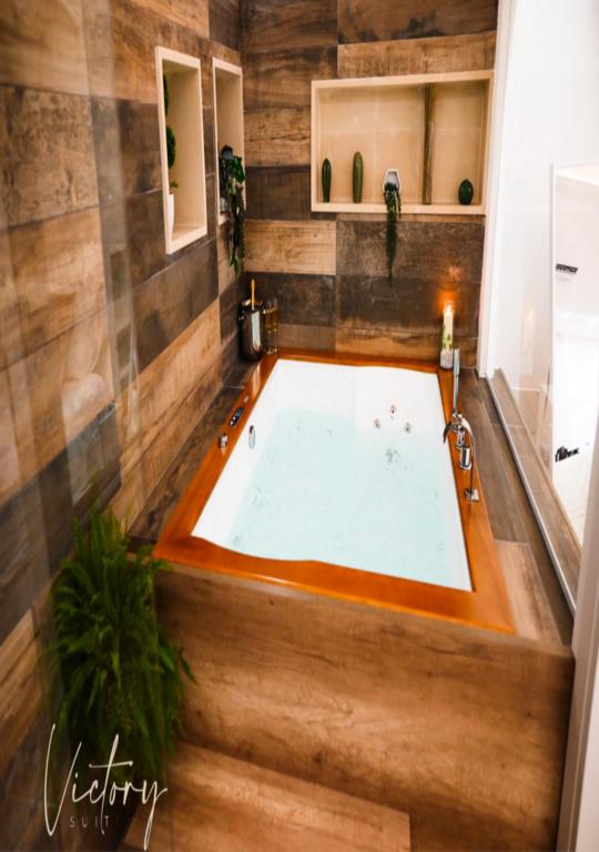 a jacuzzi tub in a bathroom with wooden walls at Victory Suite 31 in Brindisi