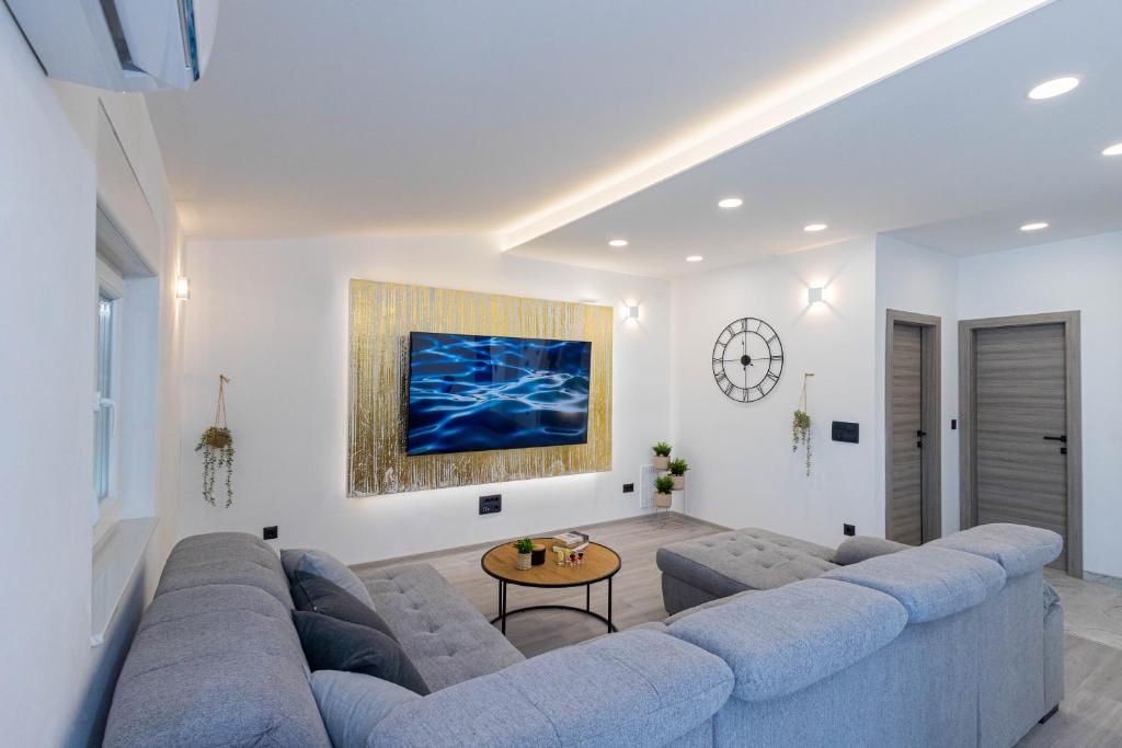 a living room with a blue couch and a table at Luxury Apartment SeaYou Kaštela in Kaštela