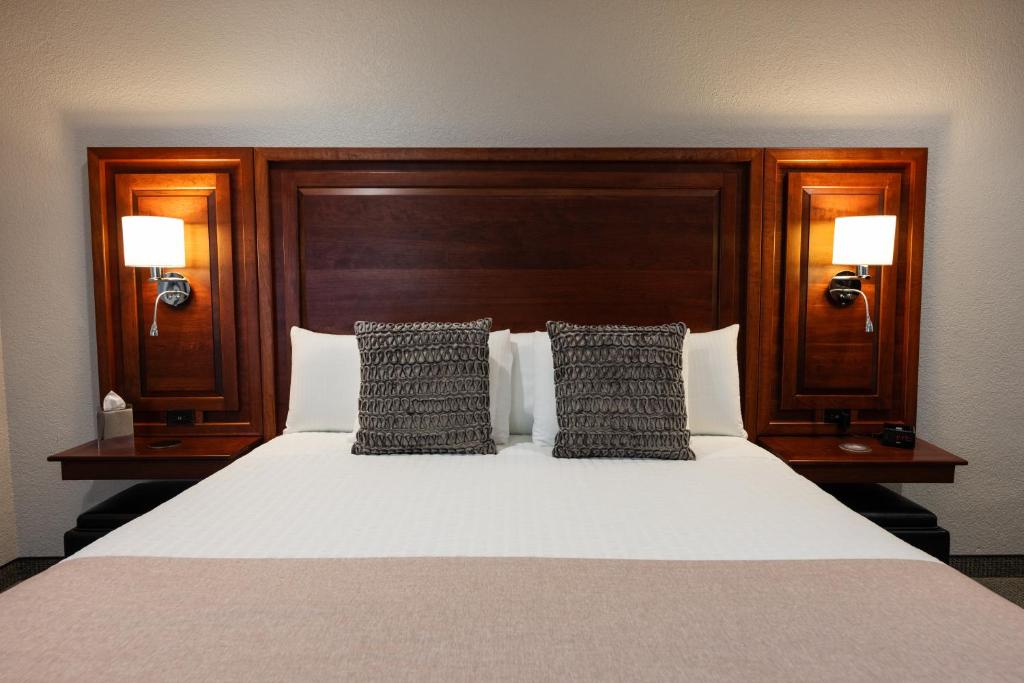 a bedroom with a bed with two lamps on it at Hillsdale College Dow Hotel and Conference Center in Hillsdale