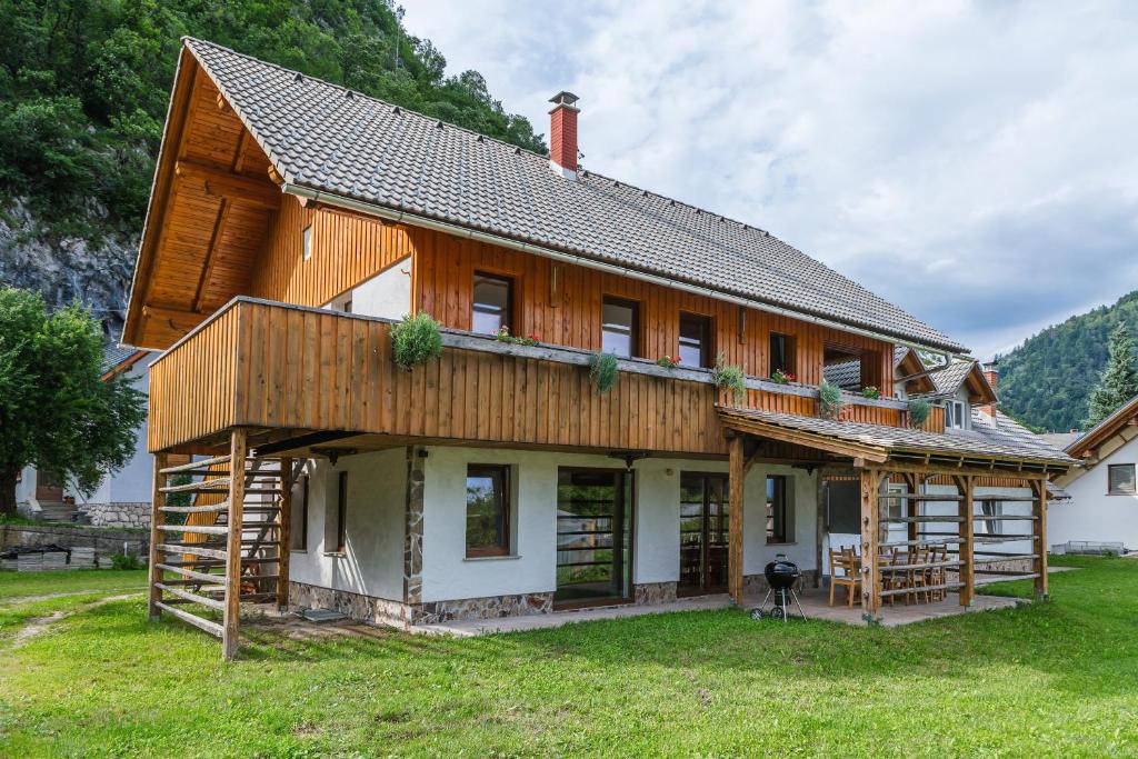 a large wooden house on a grass field at Pogacar Apartments in Bled