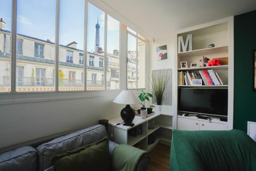 un soggiorno con divano, TV e finestre di Eiffel Tower Vicinity Gem a Parigi