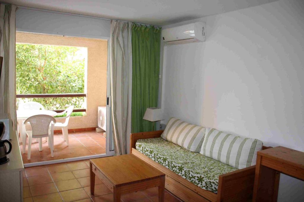 a living room with a couch and a table and a window at Sea & sugar in Linguizzetta