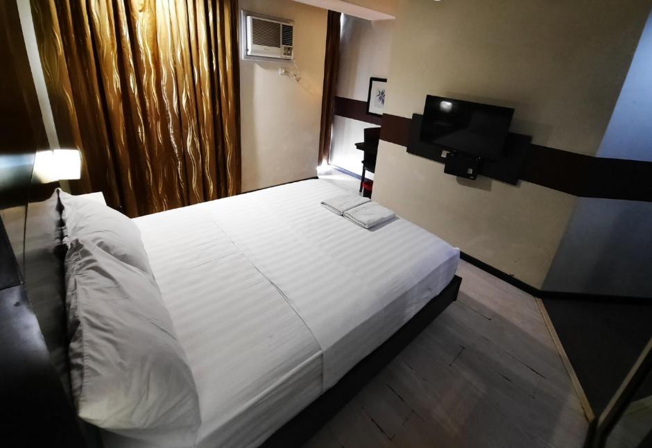 Postel nebo postele na pokoji v ubytování Lorenzzo Suites Hotel Makati