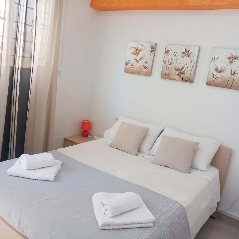 a bedroom with a white bed with two towels on it at Studio Victory Chania in Chania