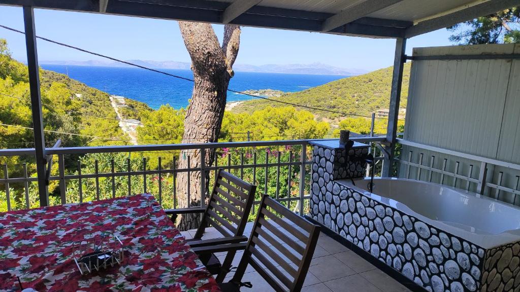 a balcony with a bath tub and a table and chairs at Villa tusia in Vravrona