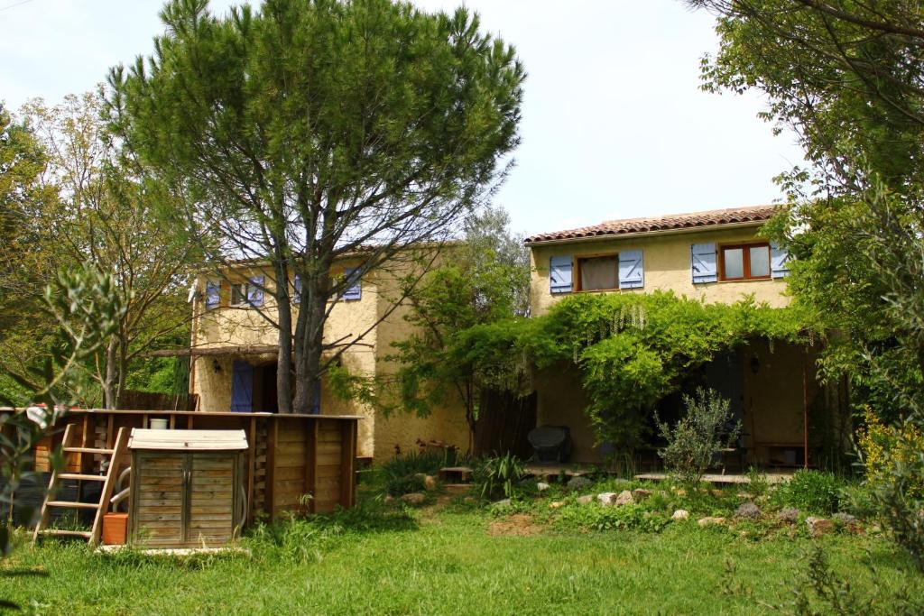 una casa con un árbol en el patio en Le Clos des Sources, en Correns