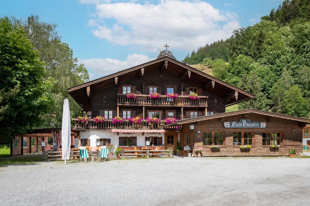 a wooden building with a balcony with flowers on it at Ferienwohnungen „Zum Bauern“ in Oberaudorf