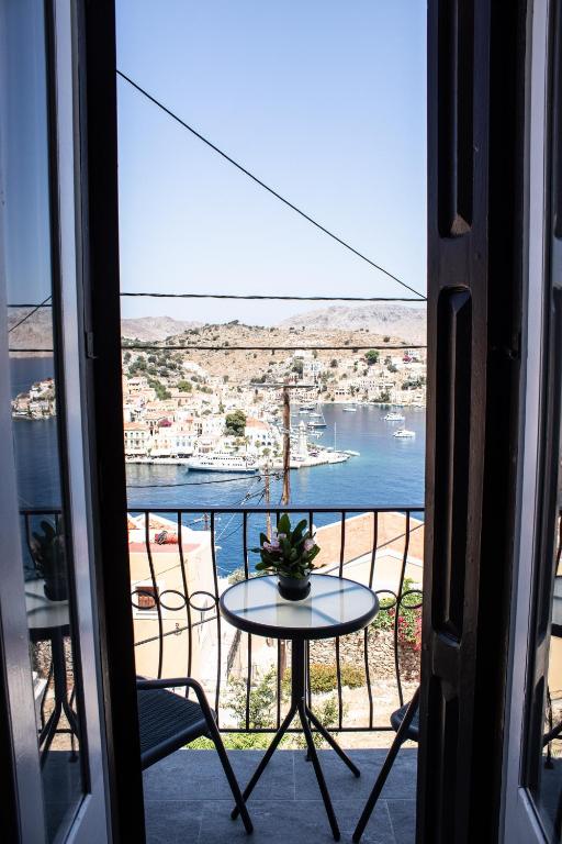 a balcony with a table and a view of a harbor at Duchess Harbour View in Symi