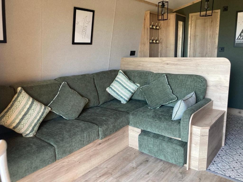 a green couch with pillows in a living room at Chapel Fields Holiday Park in Chapel Saint Leonards