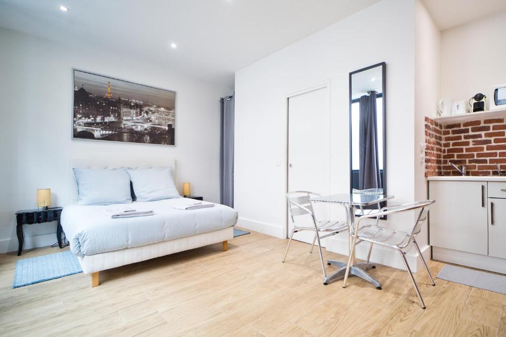 une chambre avec un lit, une table et une chaise dans l'établissement Loft style apartment, à Paris