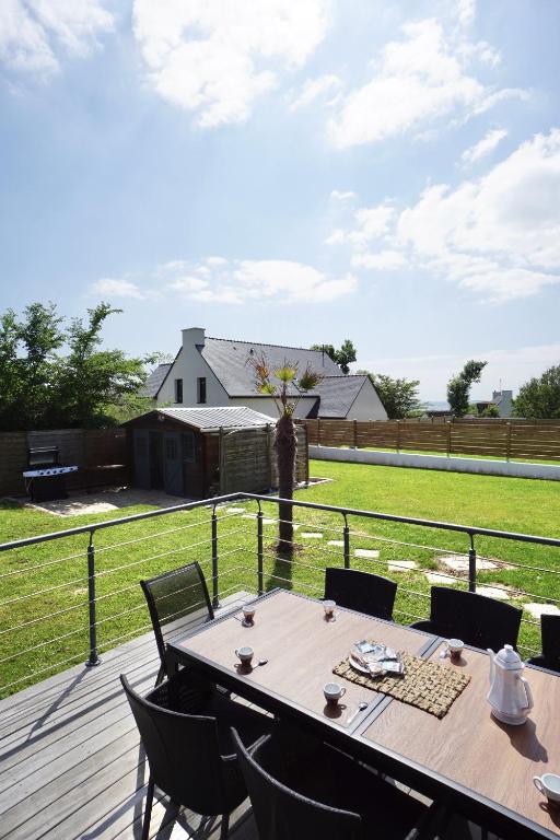 une table sur une terrasse avec vue sur un champ dans l'établissement Villa Anne - 500m de la mer - SPA, à Moëlan-sur-Mer