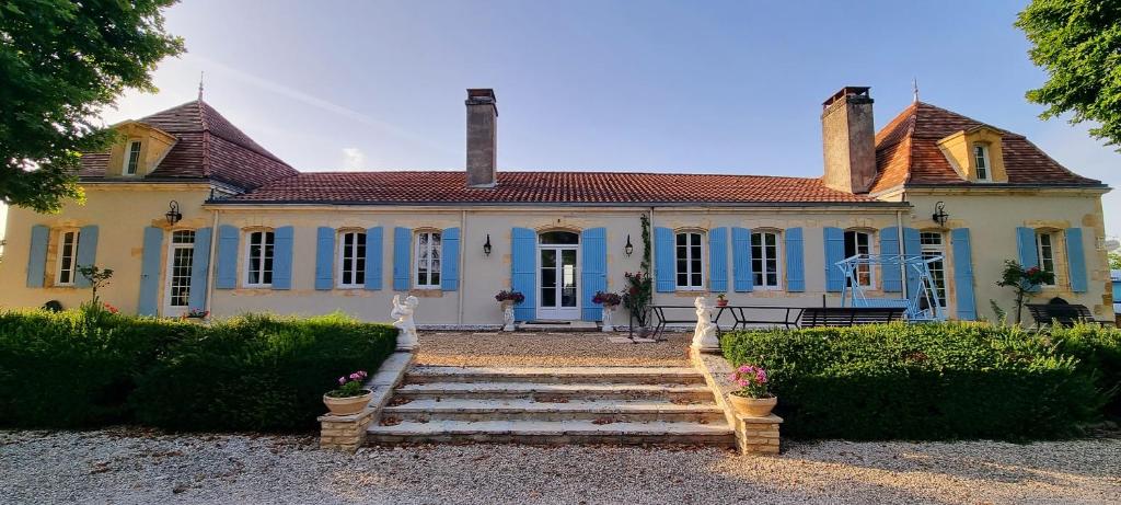 une maison ancienne avec un escalier en face de celle-ci dans l'établissement Bergerac Chambre d'hôte oiseaux de paradis, à Bergerac
