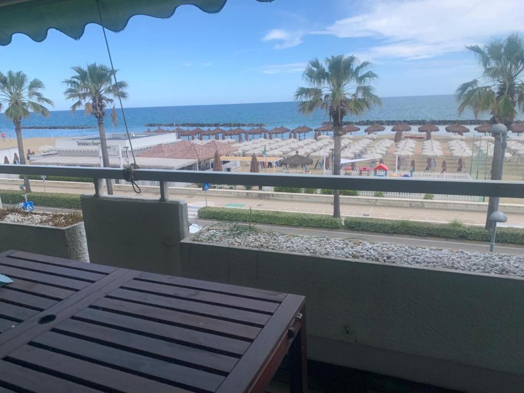 Una vista de una playa con palmeras y el océano. en FronteMare Luxury, en Montesilvano