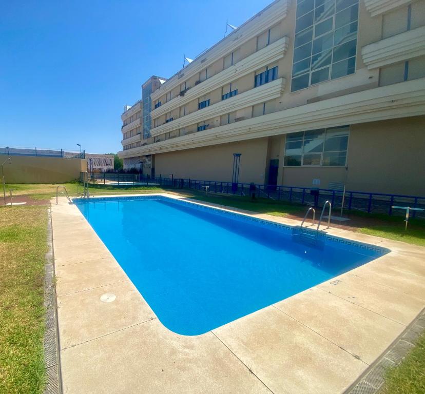 Bazén v ubytovaní FIBES Apartamento con piscina y parking gratis alebo v jeho blízkosti