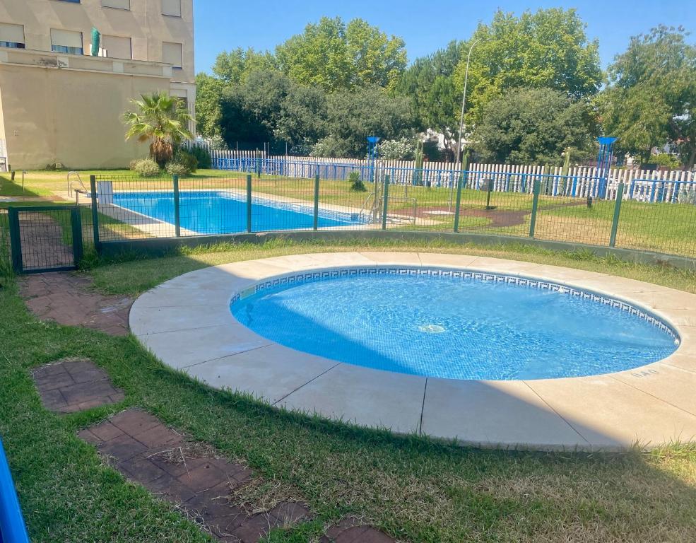 Bazén v ubytovaní FIBES Apartamento con piscina y parking gratis alebo v jeho blízkosti