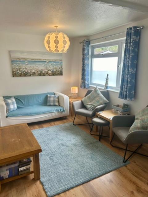 a living room with a blue couch and chairs at Rosecraddoc Lodge 23 in Liskeard