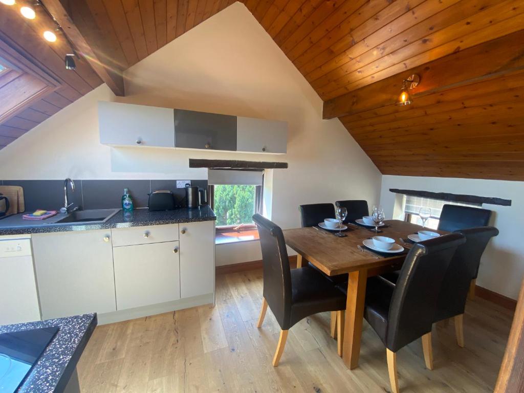 een keuken en eetkamer met een houten tafel en stoelen bij Craven Garth Cottages in Rosedale Abbey