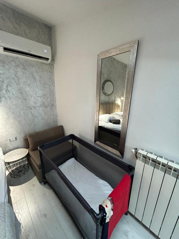 a small room with a bed and a mirror at Apartments Oliva in Poreč
