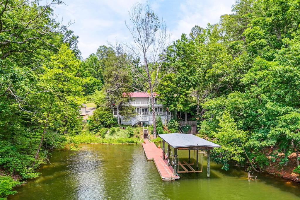 a house on a dock in the middle of a river at Smith Mountain Lake Cottage with Dock and Fire Pit! in Gladehill