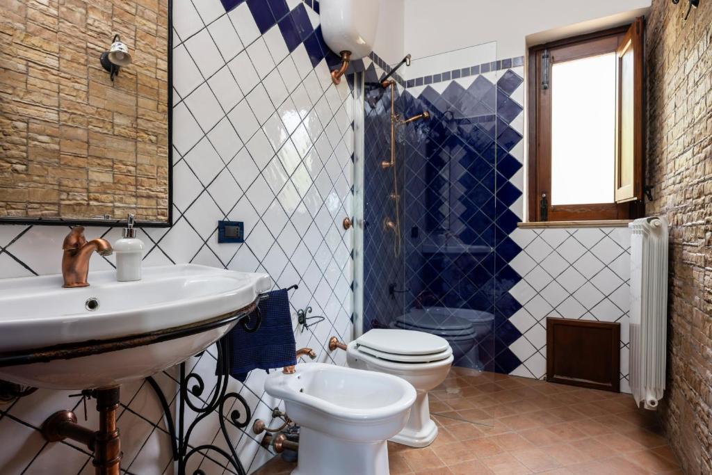 une salle de bains avec lavabo et toilettes dans l'établissement Villa Granci con Piscina by Wonderful Italy, à Polizzi Generosa