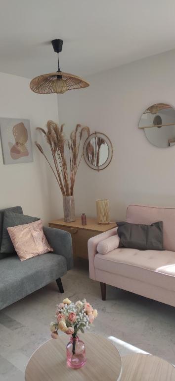un salon avec deux canapés et une table dans l'établissement L'appartement de la chance, au Cap d'Agde