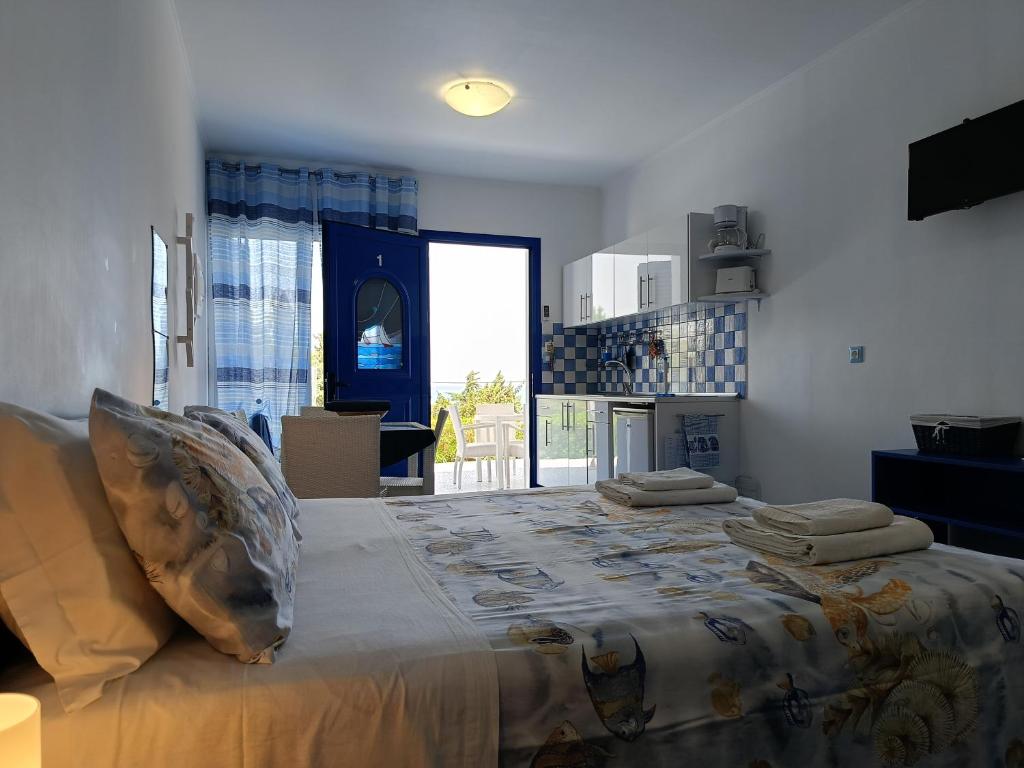 una camera da letto con un letto grande con cuscini sopra di Bouganville Studios Stegna a Archangelos
