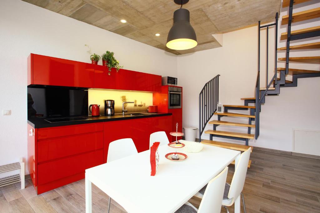 a kitchen and dining room with a white table and red cabinets at Alte Scheune Bruns in Lehmen