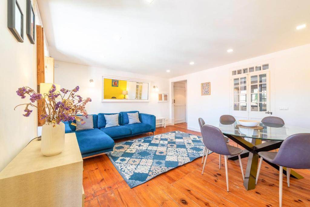 a living room with a blue couch and a glass table at GuestReady - Sunshine Belém in Lisbon