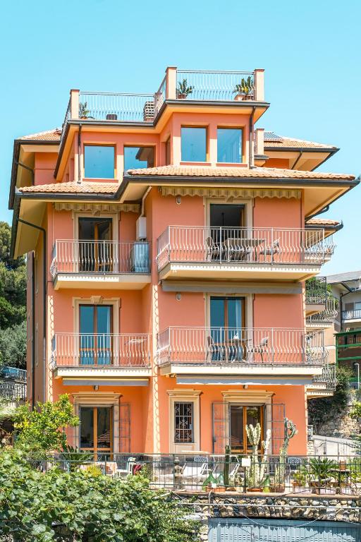 an orange building with balconies on the side of it at Kriss Apartments in Deiva Marina