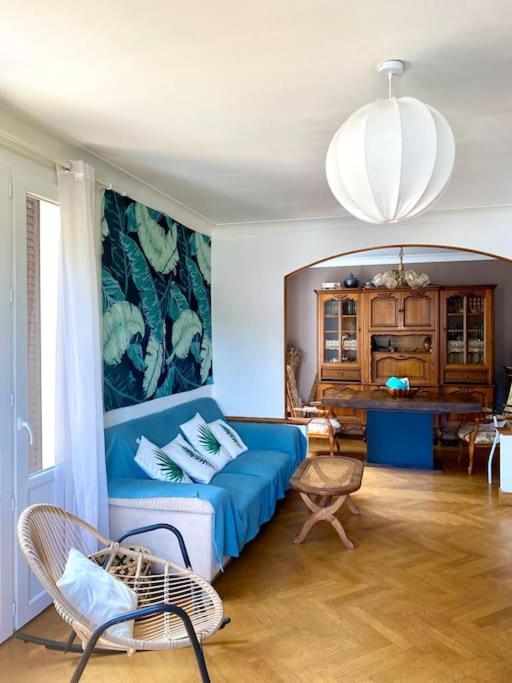 un salon avec un canapé bleu et une table dans l'établissement La Terrasse du Fourcat, à Saint-Paul-de-Jarrat