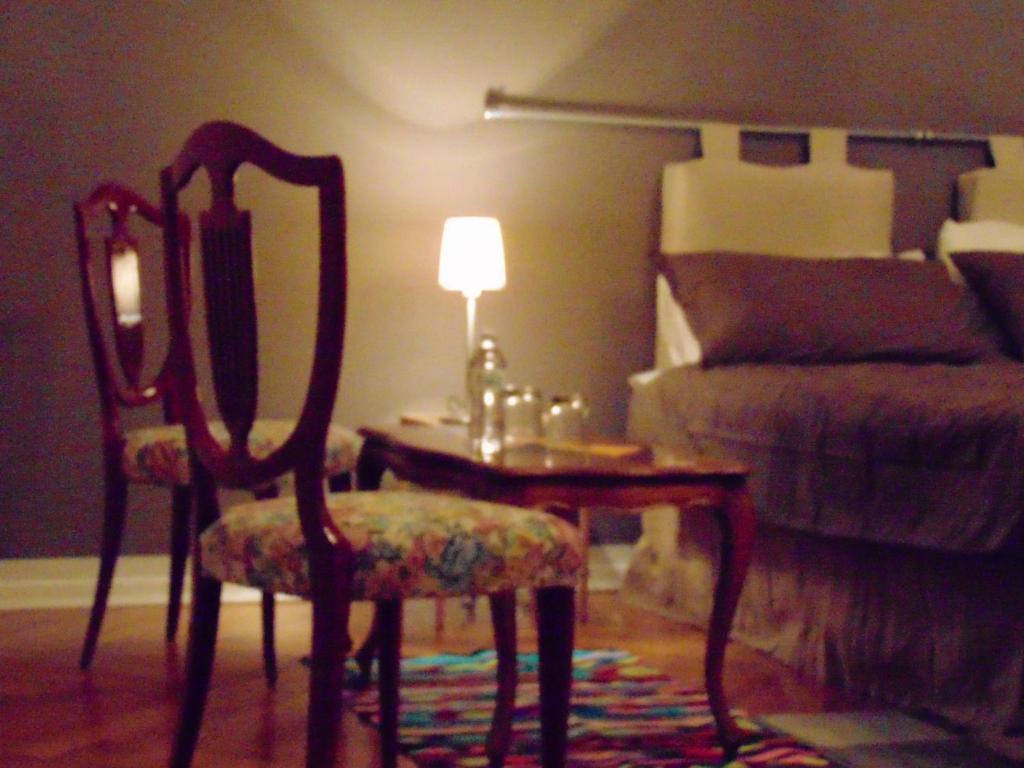 トリエステにあるAffittacamere San Lazzaroのテーブル、椅子、ランプが備わる部屋