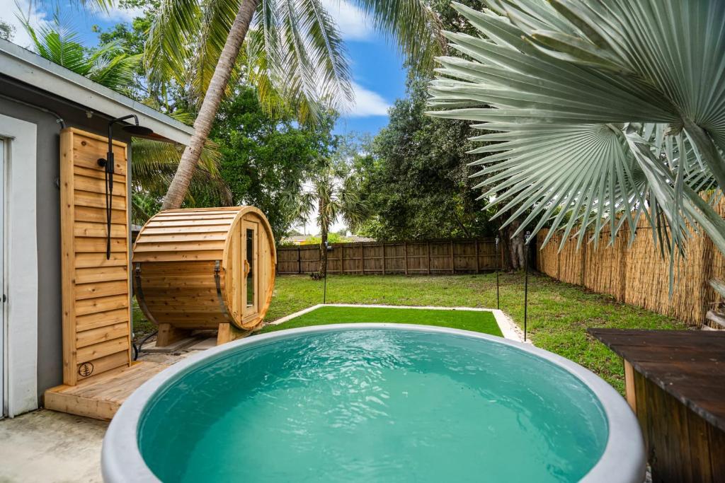 a swimming pool in a backyard with a palm tree at Zen Retreat - Sauna Pool Cold Plunge & More in Fort Lauderdale