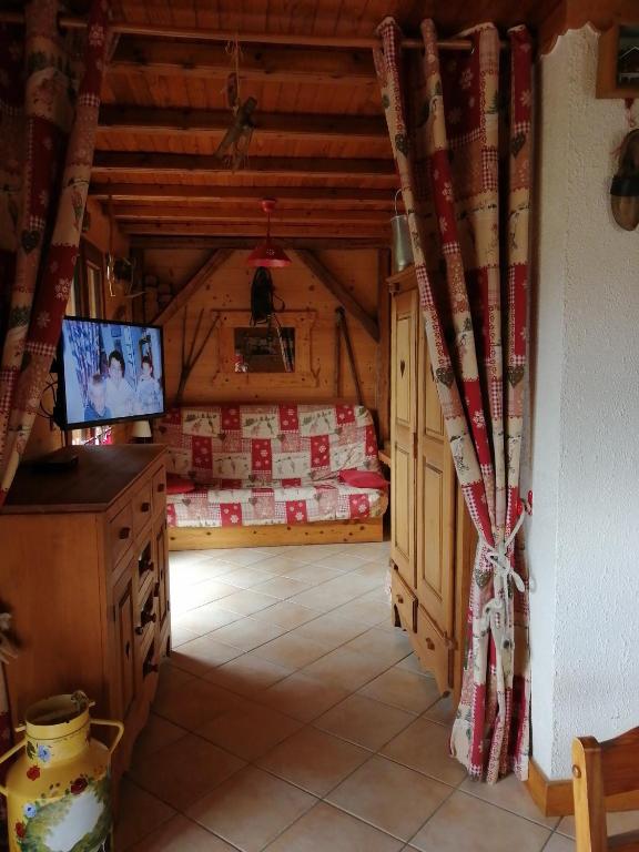 une chambre mansardée avec une télévision et une pièce avec un mur dans l'établissement appartement sur domaine des Sybelles St Jean d'Arves, à La Chal