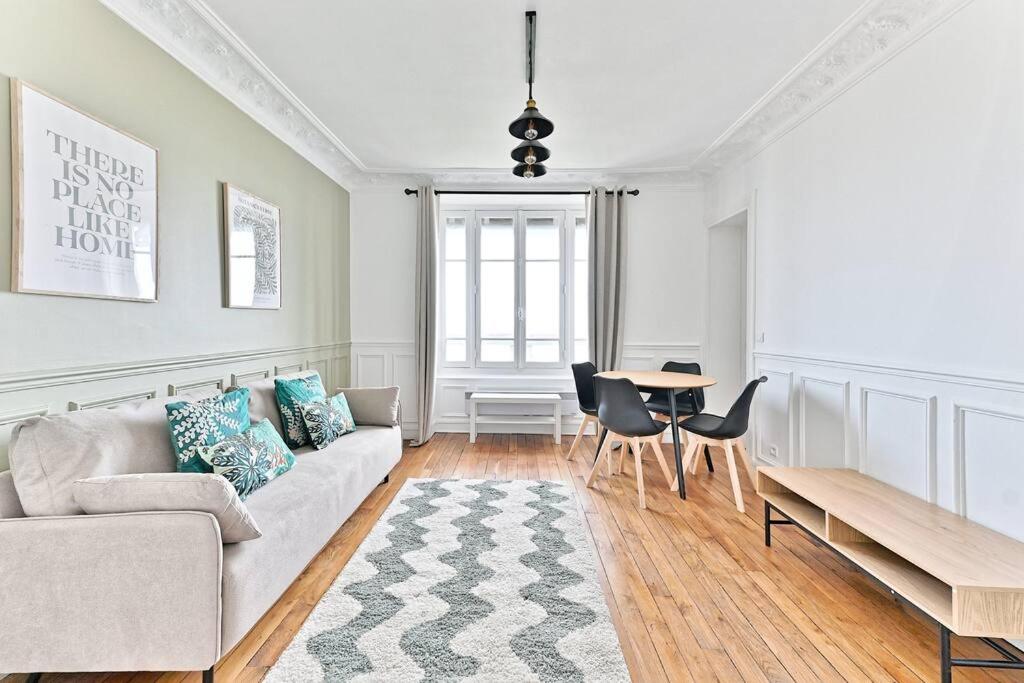 un salon avec un canapé et une table dans l'établissement Appartement Vue sur Tour effeil Defense, à Puteaux