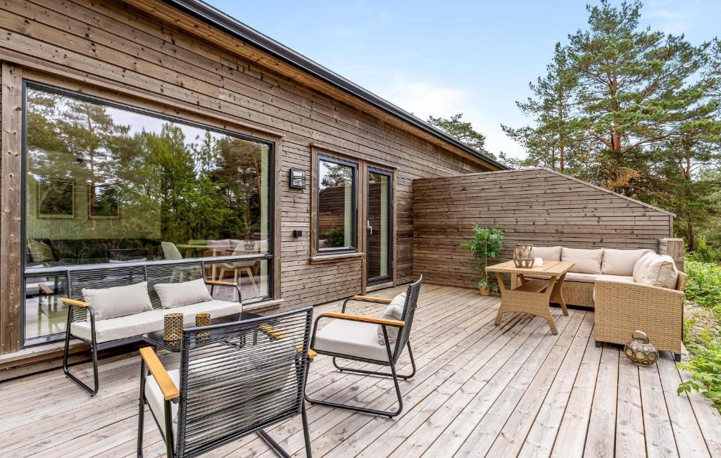 a patio with chairs and a table on a wooden deck at 4 Bedroom Stunning Home In Risør in Risør