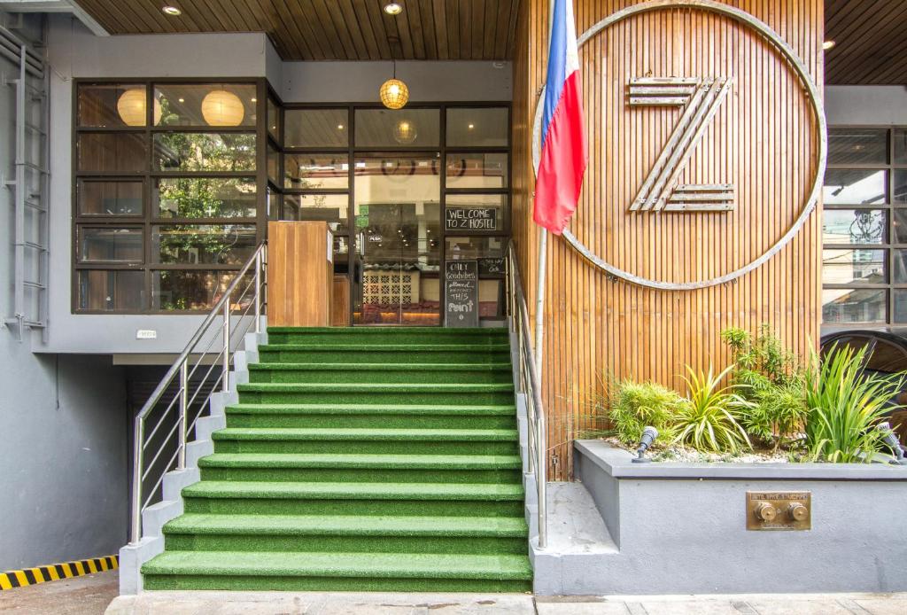 uma escada que leva a um edifício com uma bandeira em Z Hostel em Manila