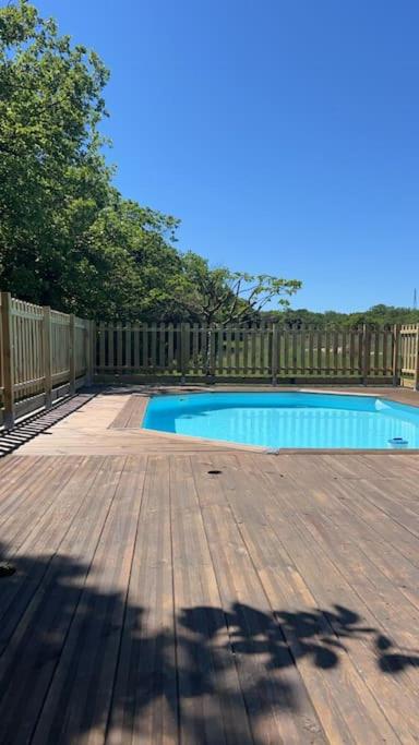- une piscine sur une terrasse en bois à côté d'une clôture dans l'établissement Chalet en Drôme Provençale, à Roussas