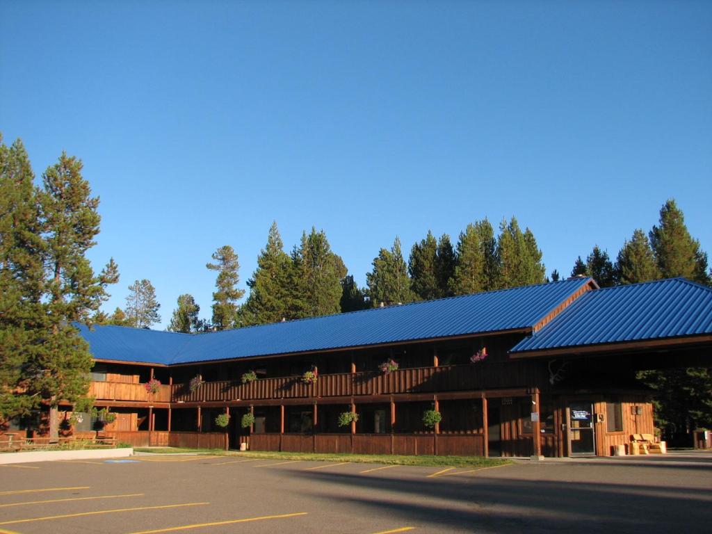 a large wooden building with a blue roof at Willamette Pass Inn & Chalets in Odell Lake