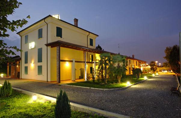 a large white house with lights on a street at Hotel Gabarda in Carpi
