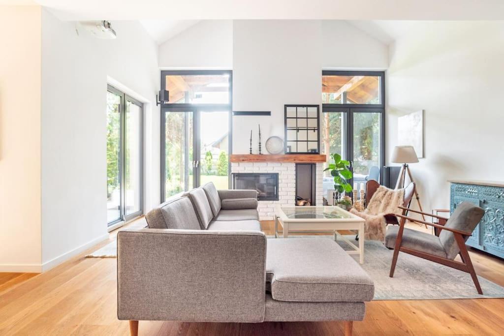 a living room with a couch and a fireplace at Parkowa Garden in Michałowice